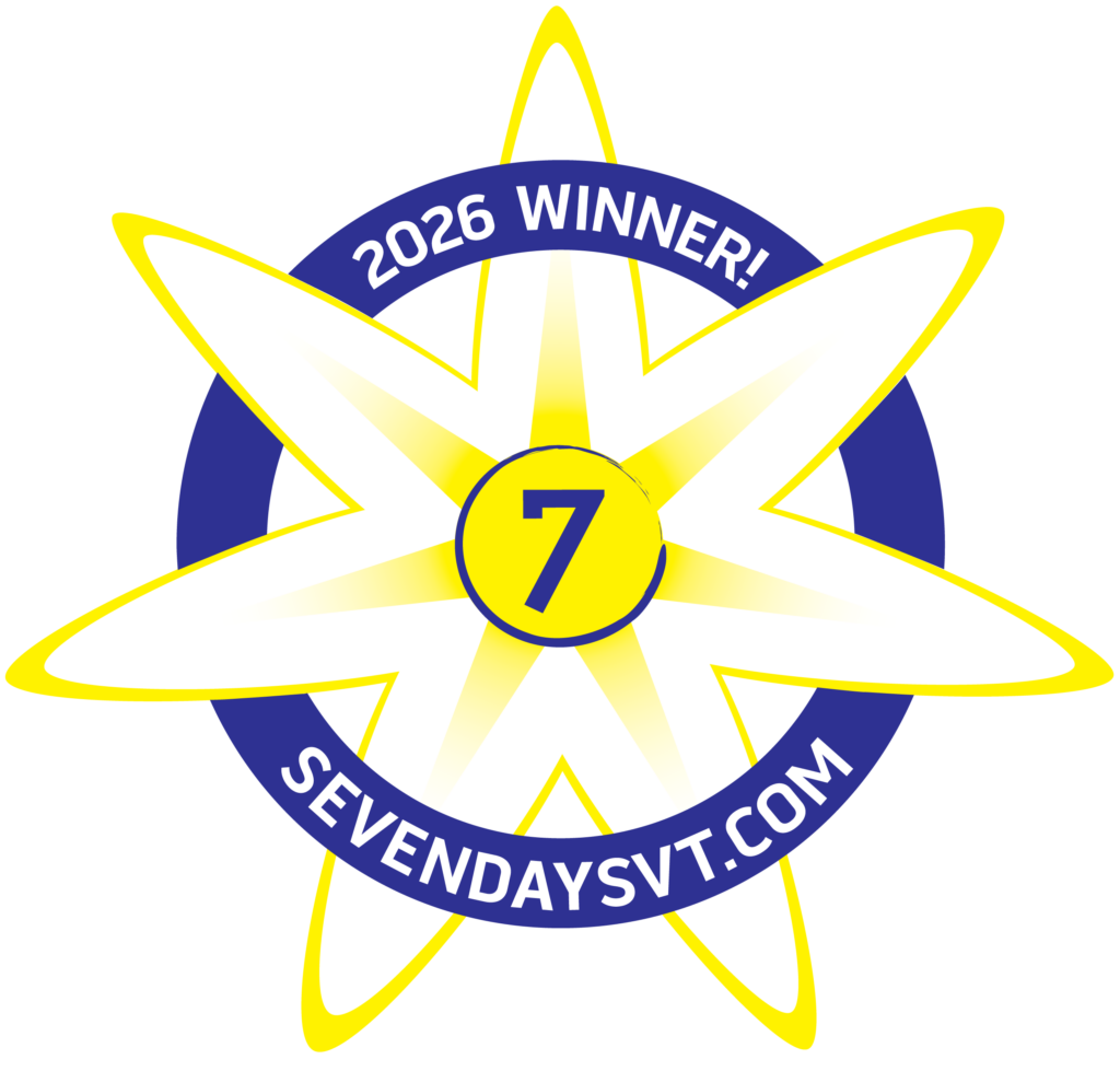 A white flower with the number 7 in the middle and a circle inset that reads "2026 winner" and ' Sevendaysvt.com"
